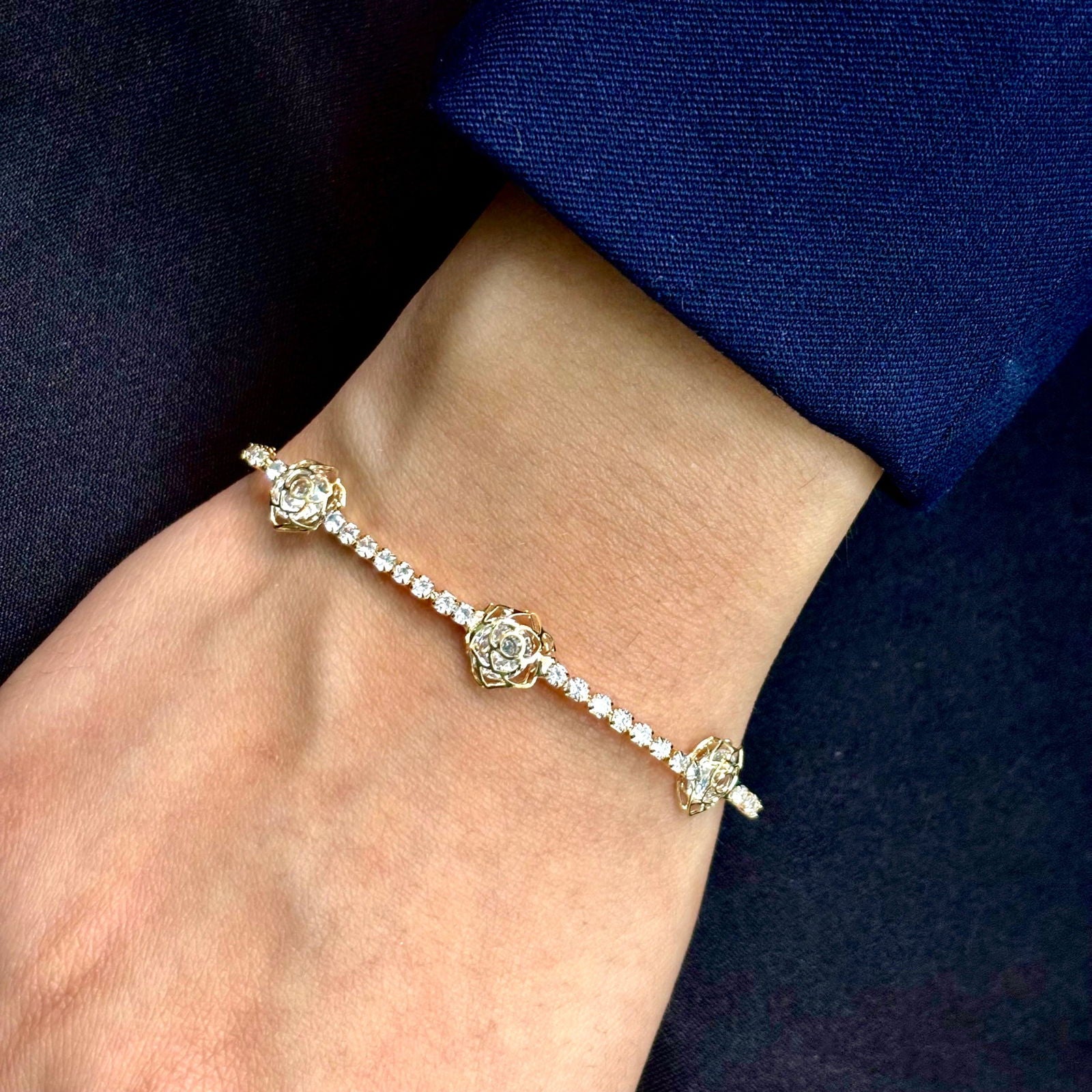 Model's hand close-up on dark background showcasing elegant waterproof 18K gold plated cz tennis bracelet - hypoallergenic premium cz tennis bracelet gift for her under 2000 - waterproof chic cz gold tennis bracelet anniversary gift under 2000 - affordable gold tennis bracelet stainless steel gift under 1500 - hypoallergenic cz tennis bracelet everyday wear - silver tennis bracelet gift for her - Rakhi gifts for sister under 2000 - jewelry Raksha Bandhan gifts