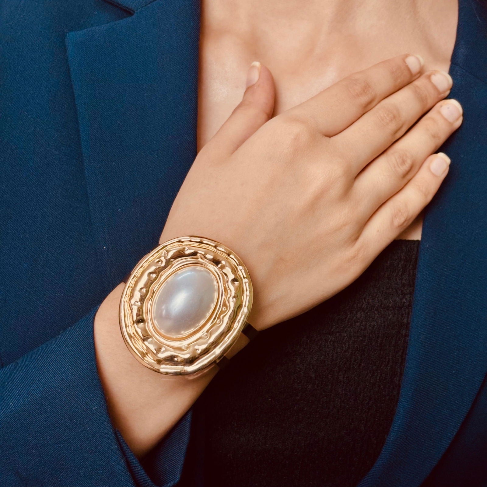 Close-up of model's hand showcasing anti-tarnish 18K gold plated oversized pearl stainless steel chunky brass bracelet birthday gift for her ideas under 2000 - waterproof 18K gold plated large pearl cuff bangle anniversary gift ideas under 1500 - Model wearing chic anti-tarnish 18k gold plated three heart clustered pearl stainless steel necklace birthday gift for her ideas under 2000 - Rakhi gifts for sister under 2000 - jewelry Raksha Bandhan gifts