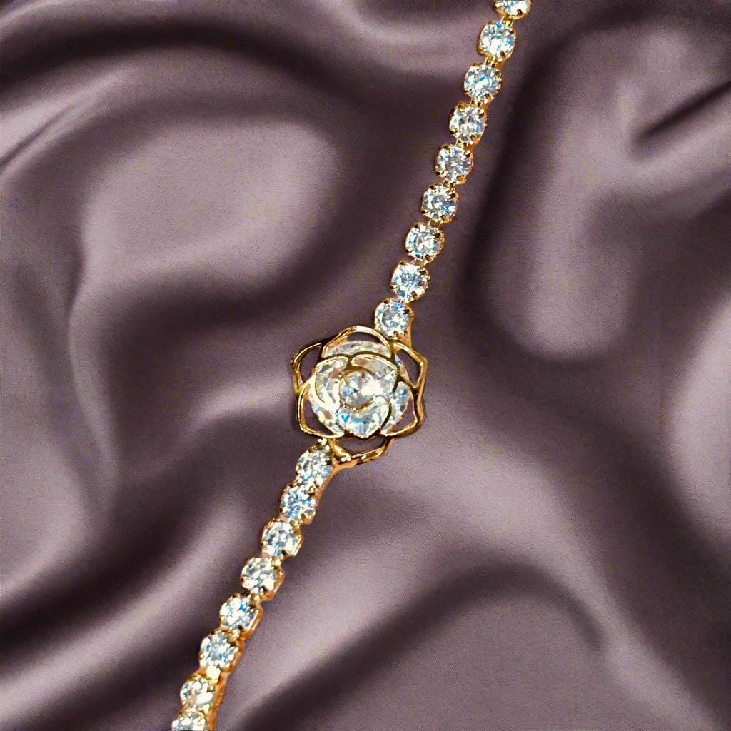 Close-up shot of flat lay riviera bracelet on satin cloth - elegant waterproof 18K gold plated cz tennis bracelet - hypoallergenic premium cz tennis bracelet gift for her under 2000 -  waterproof chic cz gold tennis bracelet anniversary gift under 2000 - affordable gold tennis bracelet stainless steel gift under 1500  - hypoallergenic cz tennis bracelet everyday wear - silver tennis bracelet gift for her - Rakhi gifts for sister under 2000 - jewelry Raksha Bandhan gifts