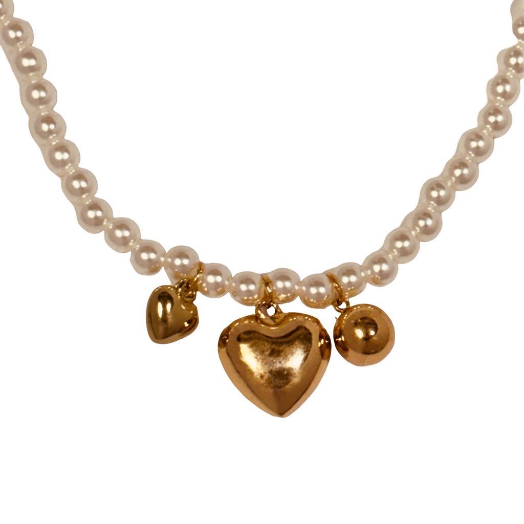 Close-up of gold hearts and mini pearl beads on fine chain