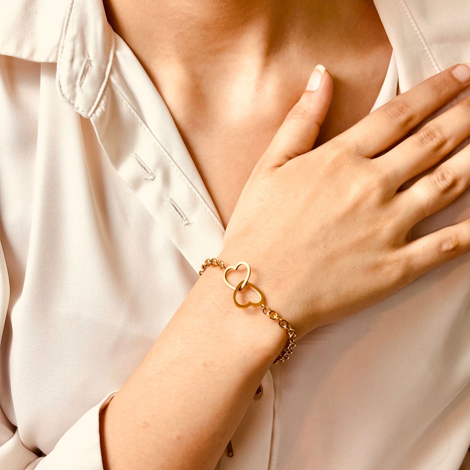Model showing dainty heart shapes and wrist curve fit - anti‑tarnish gold plated interlocked heart bracelet India - minimalist 18k gold plated interlocked hearts bracelet - hypoallergenic double heart chain bracelet 18k - premium heart-to-heart adjustable gold bracelet - romantic gift 18k gold plated interlocked hearts chain bracelet