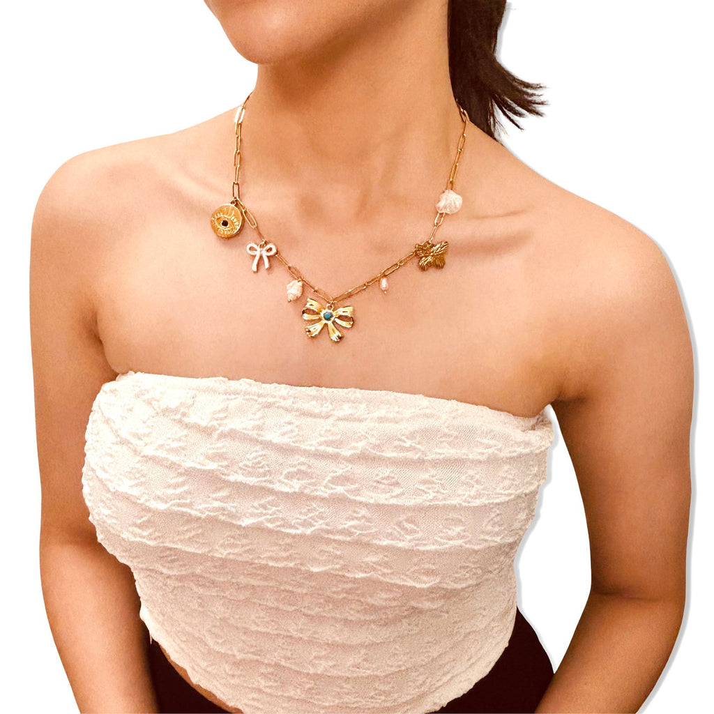Model infront of white background wearing anti-tarnish evil eye and bow charm 18K gold-plated baroque pearl charm necklace birthday gift for her under 2000 - waterproof dainty minimalist 18K gold plated stainless steel charm necklace anniversary gifts ideas under 2000 - hypoallergenic gold necklace festive gifts idea under 2000 - Rakhi gifts for sister under 2000 - jewelry Raksha Bandhan gifts