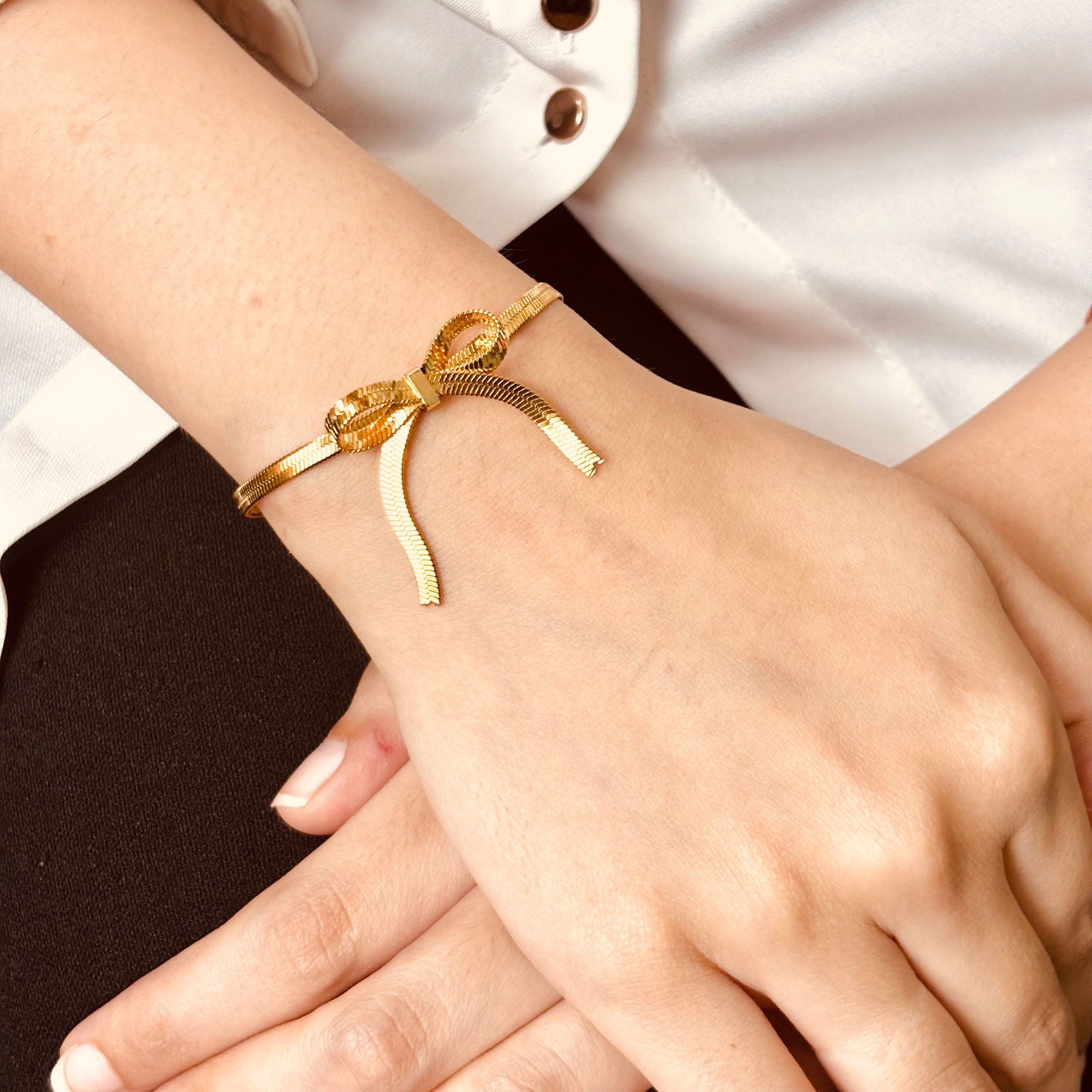 Model's hand showing anti-tarnish sleek 18K gold-plated stainless steel  snake chain bow bracelet gift for her under 1500 – dainty adjustable wrist bracelet under 1500 - waterproof minimalist 18K gold plated snake chain bow bracelet birthday gift for her under 2000 - hypoallergenic dainty snake chain bracelet anniversary gift for her under 2000 - Rakhi gifts for sister under 2000 - jewelry Raksha Bandhan gifts - affordable chic gold bangle under 1500