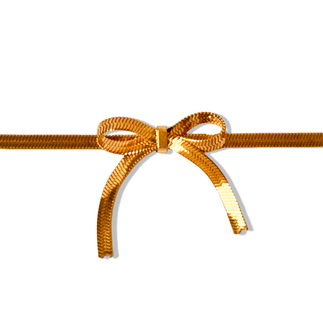 Close-up of snake chain bracelet showing bow clasp and fine texture