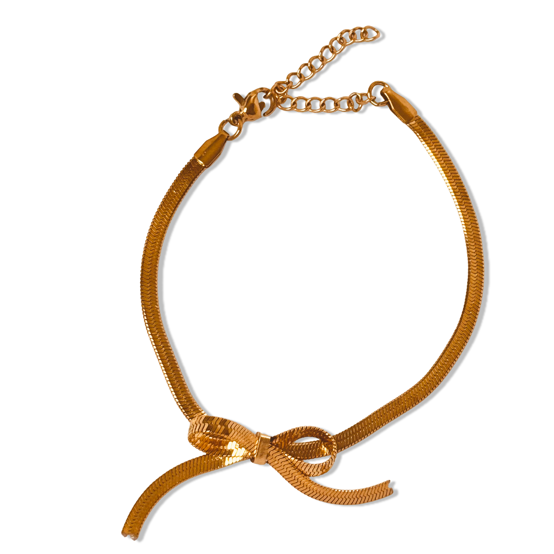 Snake chain bow bracelet displayed flat on white background - anti-tarnish sleek 18K gold-plated stainless steel  snake chain bow bracelet gift for her under 1500 – dainty adjustable wrist bracelet under 1500 - waterproof minimalist 18K gold plated snake chain bow bracelet birthday gift for her under 2000 - hypoallergenic dainty snake chain bracelet anniversary gift for her under 2000 - Rakhi gifts for sister under 2000 - jewelry Raksha Bandhan gifts - affordable chic gold bangle under 1500