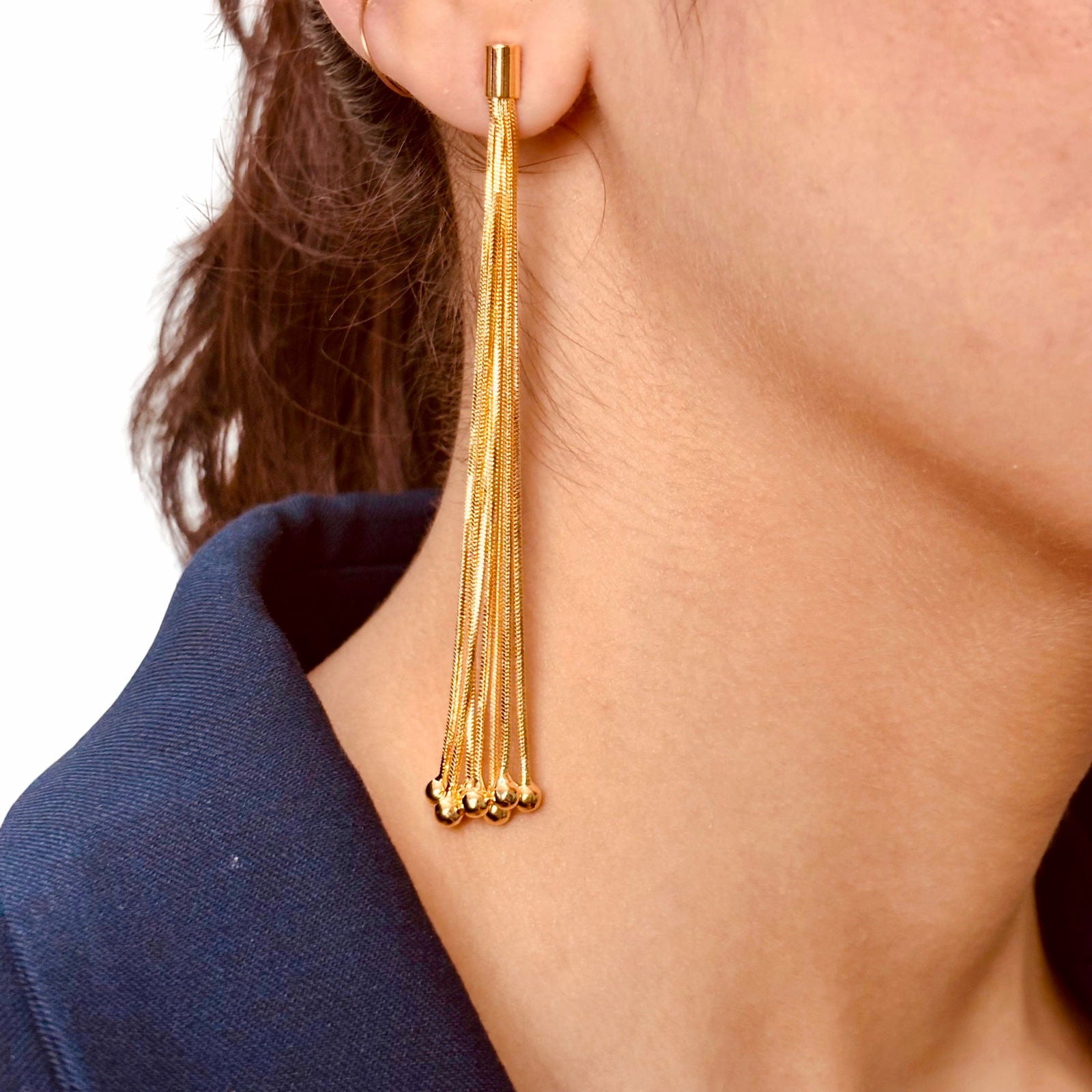 Model's close-up of tassel earring showing chains length texture and gold finish detail - Statement bold elegant gold plated earrings - hypoallergenic anti‑tarnish gold plated stainless steel earrings - waterproof gold plated chandelier earrings - Rakhi gifts for sister under 2000 - jewelry Raksha Bandhan gifts