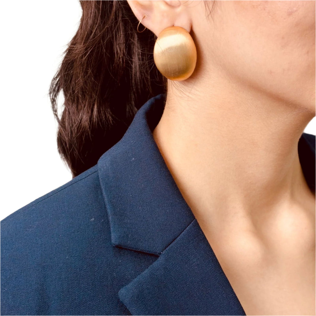 Model's close-up view of oval earrings catching light and shine - dainty chic minimalist elegant gold plated earrings - hypoallergenic anti‑tarnish waterproof nickel‑free lead‑free gold plated earrings - scratch‑resistant fade‑resistant water‑resistant gold plated earrings 