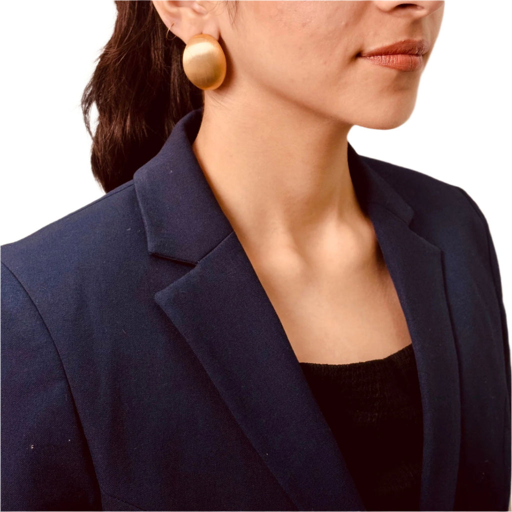 Model's angle view showing smooth oval surface with reflective finish - dainty chic minimalist elegant gold plated earrings - hypoallergenic anti‑tarnish waterproof nickel‑free lead‑free gold plated earrings - scratch‑resistant fade‑resistant water‑resistant gold plated earrings 