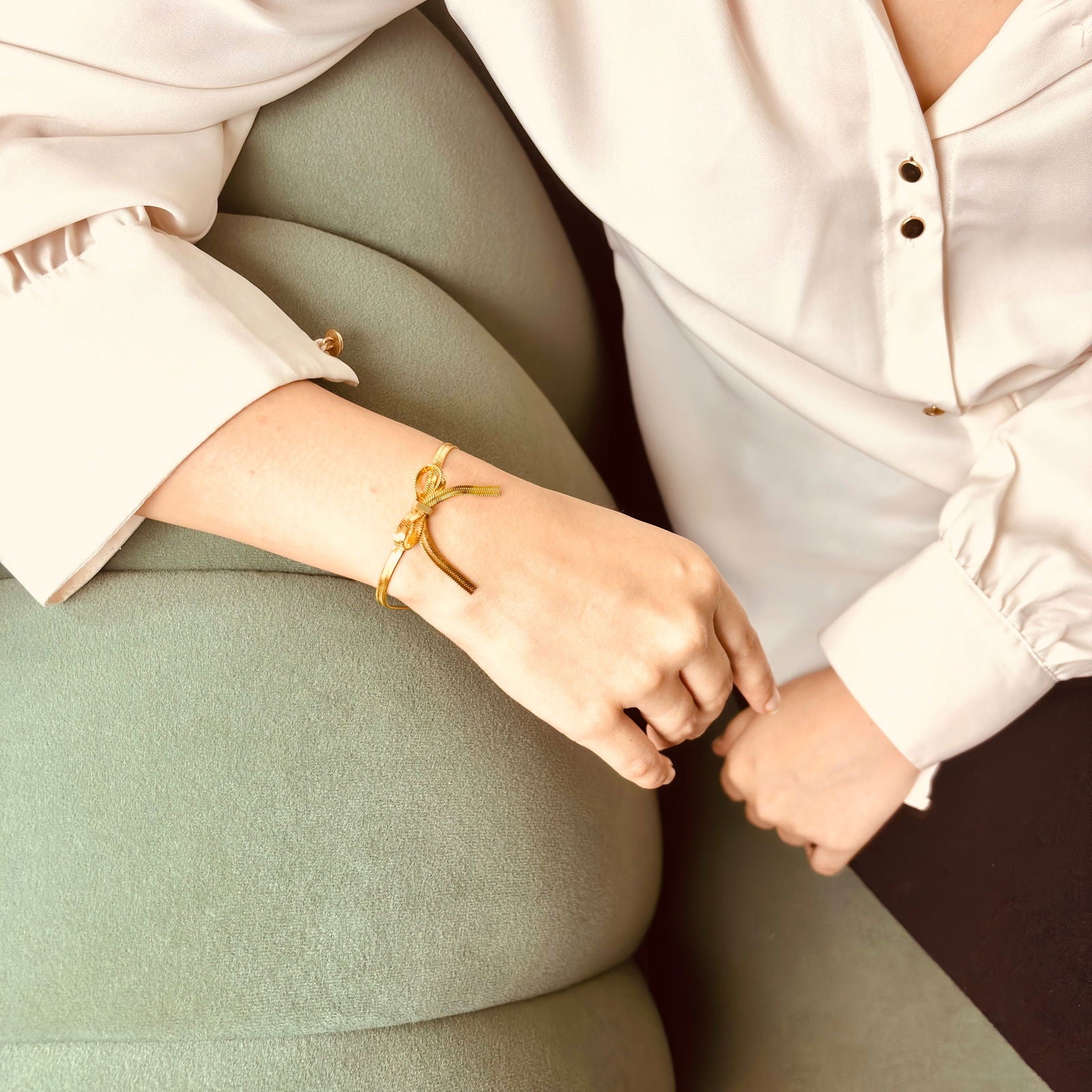 Model wearing 18K gold-plated snake chain bow bracelet – dainty adjustable wrist accessory