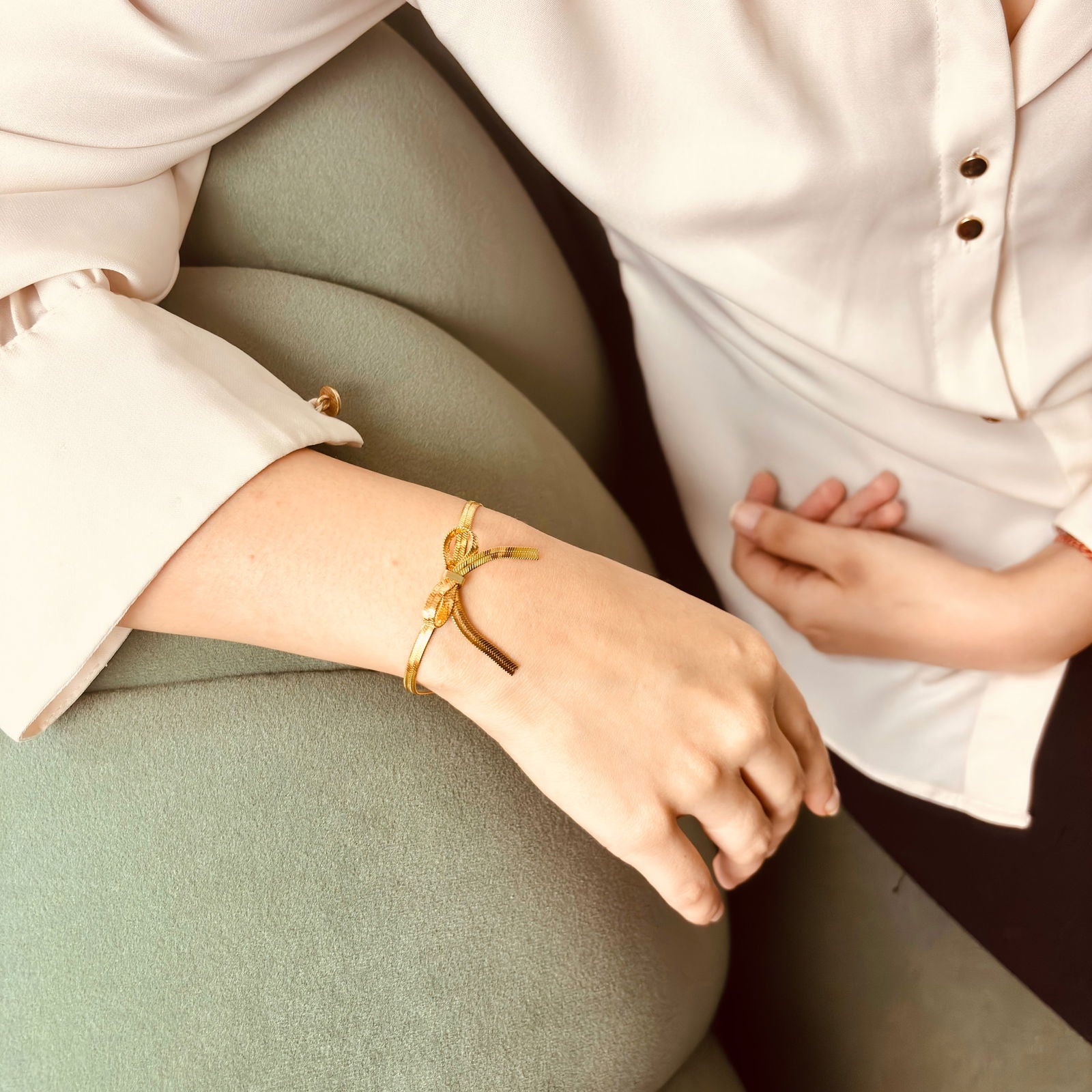 Model wearing snake chain bow bracelet – elegant layerable piece - minimalist gold plated bangle